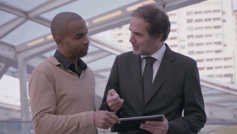 executive colleagues with tablet having conversation