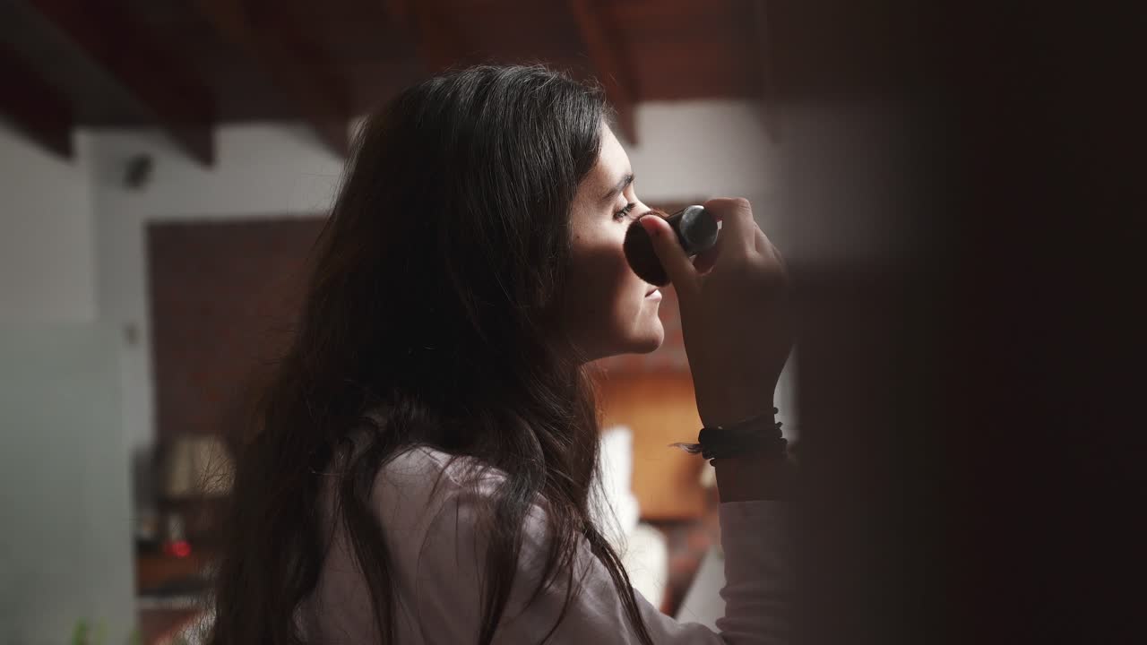 mujer joven atractiva poniendo rubor de maquillaje con un cepillo