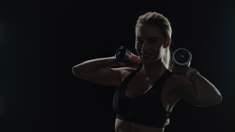 Fit-woman-posing-with-dumbbells-in-hands