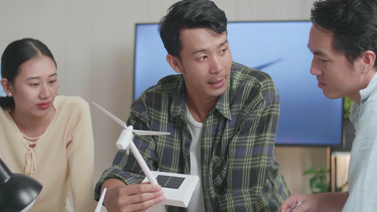 아시아 엔지니어 그룹이 사무실에서 풍력 터빈에 대한 회의를 하고 있습니다.