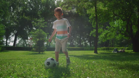 Niño-Haciendo-Ejercicio-De-Fútbol-Sobre-El-Césped-En-El-Parque.-Los-Niños-Juegan-Al-Fútbol-Al-Aire-Libre.