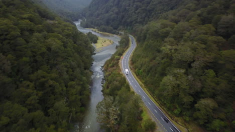 disparo de seguimiento aéreo de rv conduciendo por un río y un bosque verde