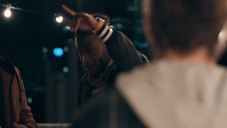 young-man-dancing-multi-ethnic-group-of-friends-having-fun-on-rooftop-at-night-enjoying-celebration-party