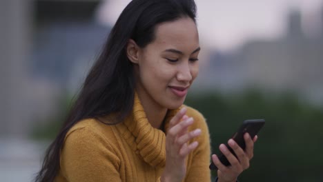 Asiatische-Frau-Benutzt-Smartphone-Und-Lächelt