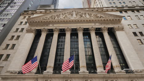 stock exchange building located on wall street in new york on the building hangs a poster