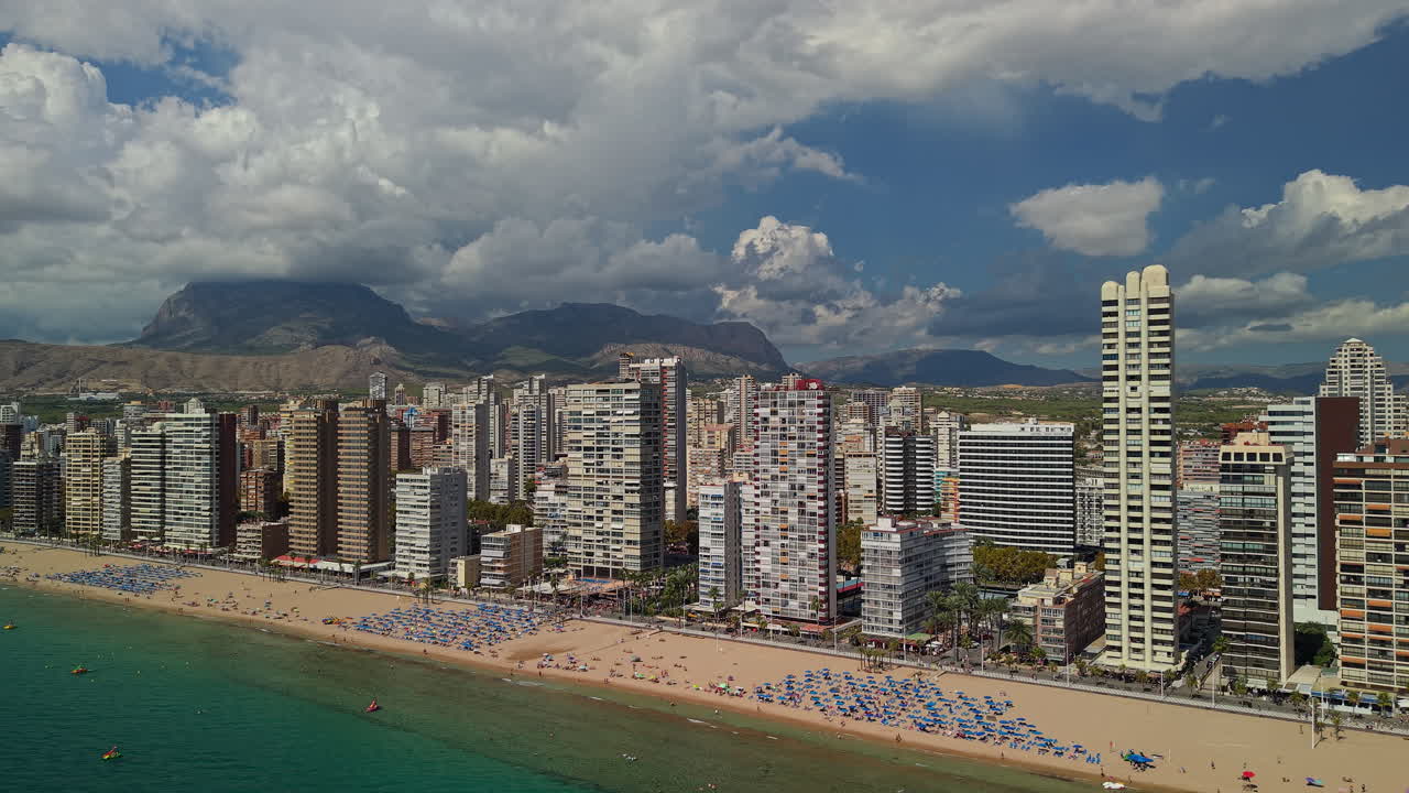 Vista aerea panoramica di una vivace spiaggia cittadina e dello skyline costiero.