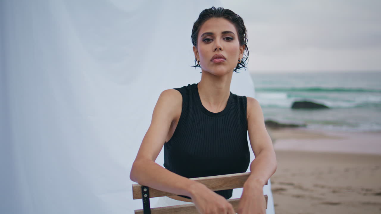 chica seductora mirando la cámara en la playa de cerca. modelo de moda sexy posando en la orilla