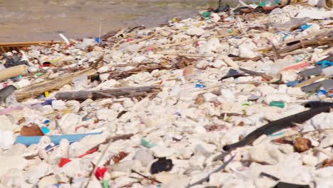 bandeja de desechos plásticos artificiales y basura que se lavan lentamente en la costa rocosa en el caribe