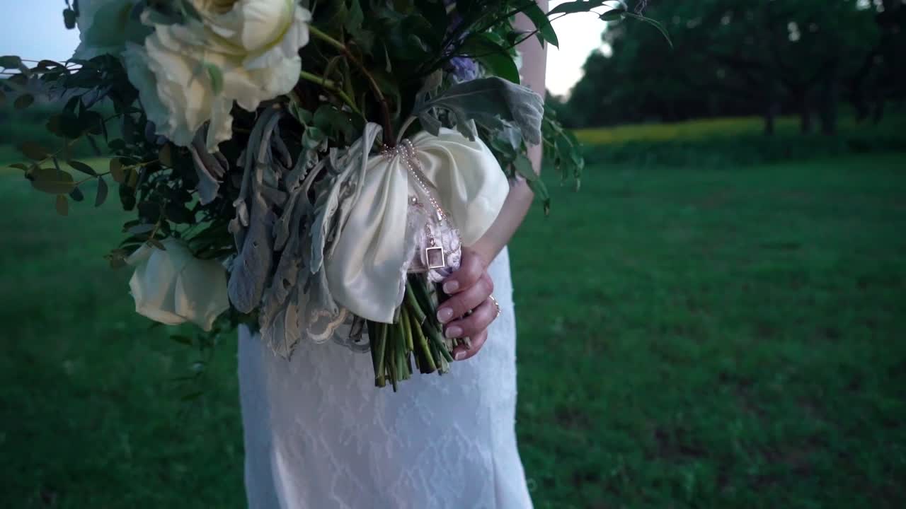 Una sposa tiene un bouquet di fiori in un campo.