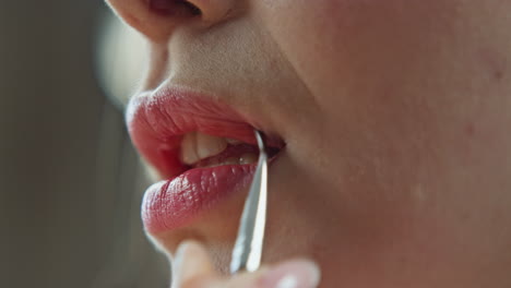 woman applying lipstick with a brush