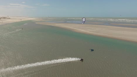 a kitesurfer cruising alone in a brazilian lagoon during a windy day