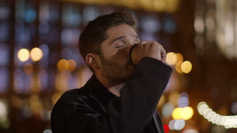 relaxed guy drinking takeaway coffee on dark street. calm man holding paper cup.