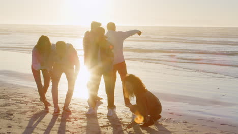 group of friends having fun on winter beach together