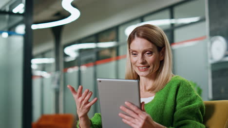 feliz empleado de video chat tableta en el lugar de trabajo de primer plano. dama gestando mano