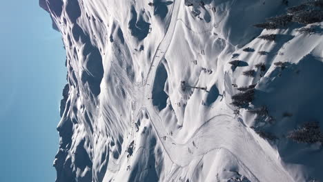 Skiers-skiing-runs-at-Avoriaz-Ski-Resort,-French-Alps,-aerial,-vertical-format