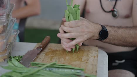 man preparing fresh green beans for cooking