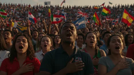 a powerful display of unity: individuals from diverse backgrounds stand together, singing with passion and pride, hand over heart, against a colorful backdrop of flags