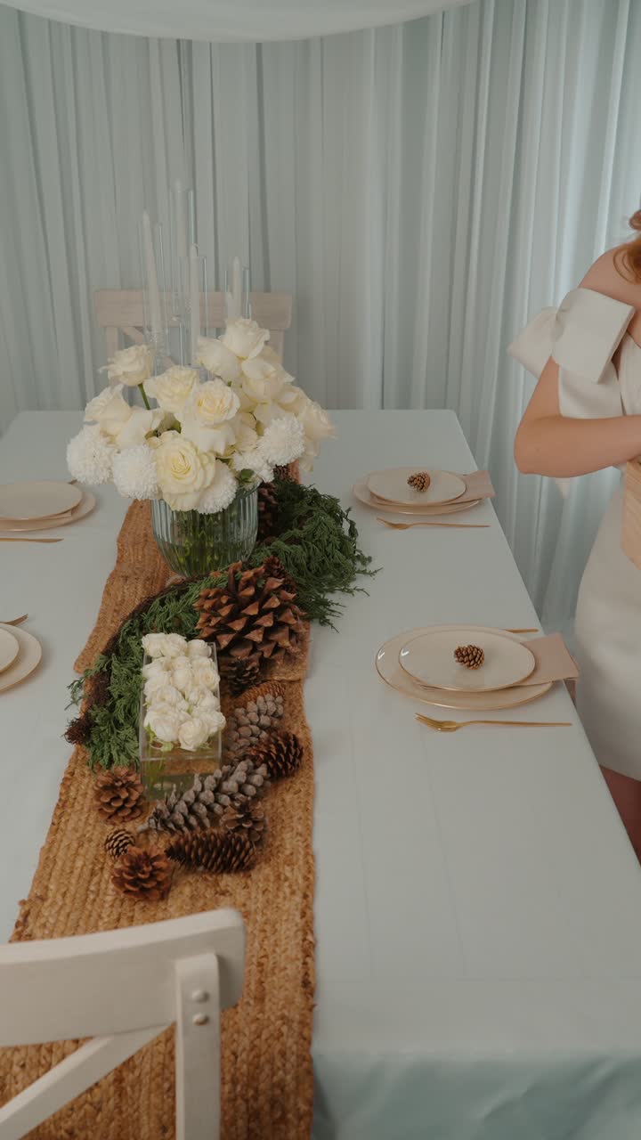un acogedor escenario navideño con rosas blancas, piñas y una elegante decoración de temporada