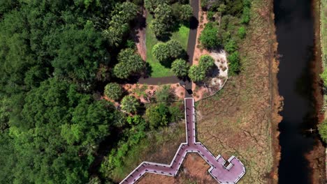 An-aerial-view-of-a-park-with-an-elevated-walkway-over-marsh-water-in-Florida-on-a-sunny-day