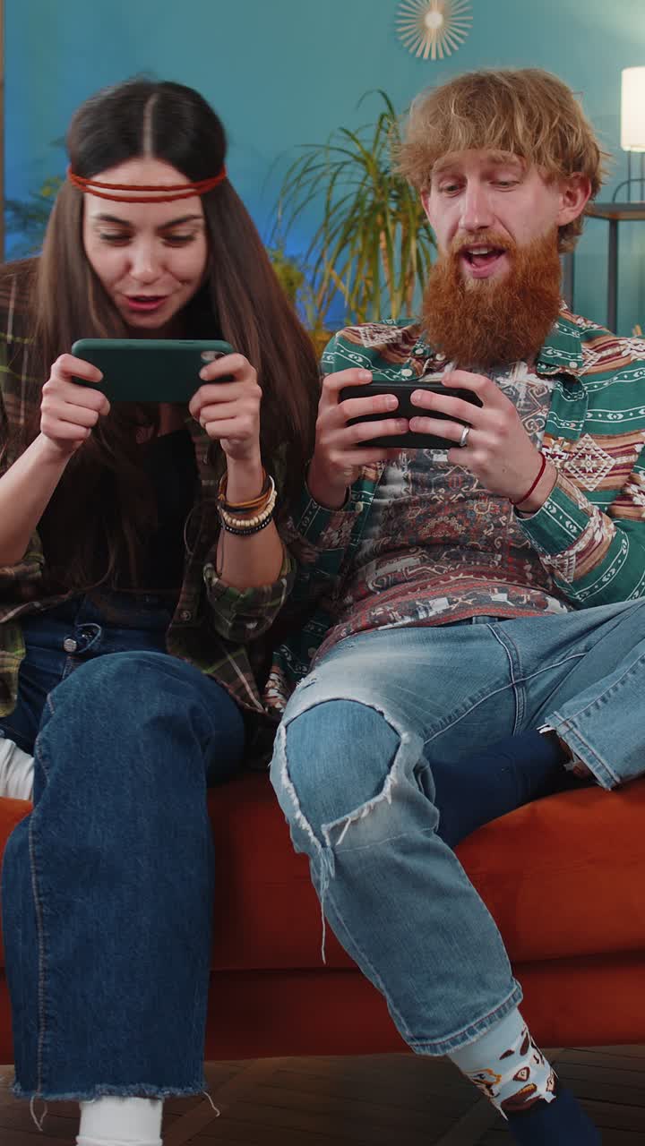 Famiglia felice coppia sposata uomo donna che gioca a videogiochi di sparatutto online su smartphone a casa