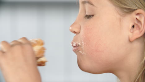 close up of girl eating sugary donut