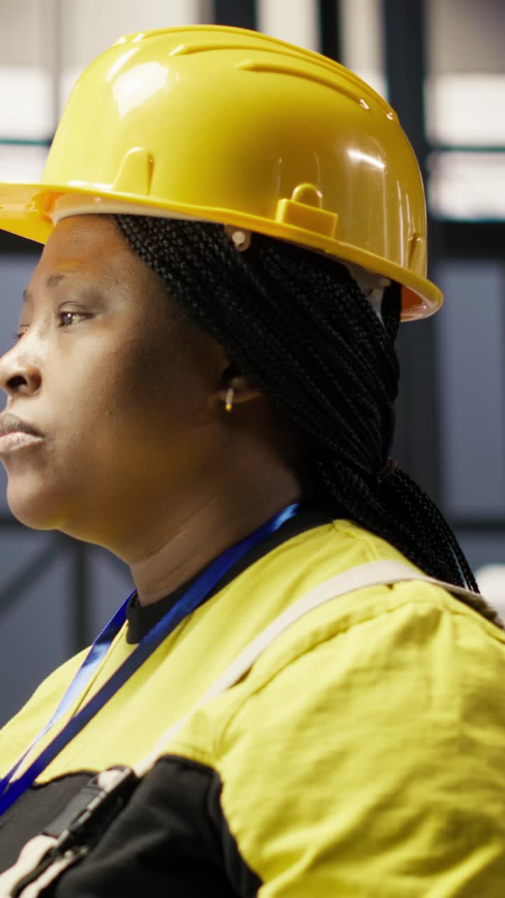 Vertical video Woman in smart factory expert uses computer to implement automated workflows