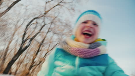 Cheerful-Little-Girl-Goes-On-A-Sled-Claps-His-Hands-Is-Happy-Winter-3