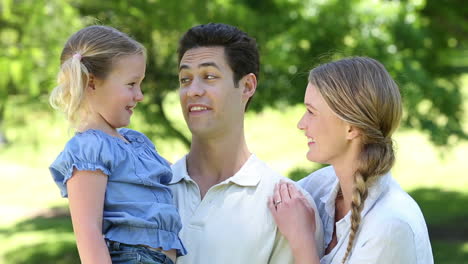 happy parents with their little girl in the park