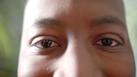 Portrait-close-up-of-eyes-of-happy-african-american-man-smiling-in-sun,-slow-motion