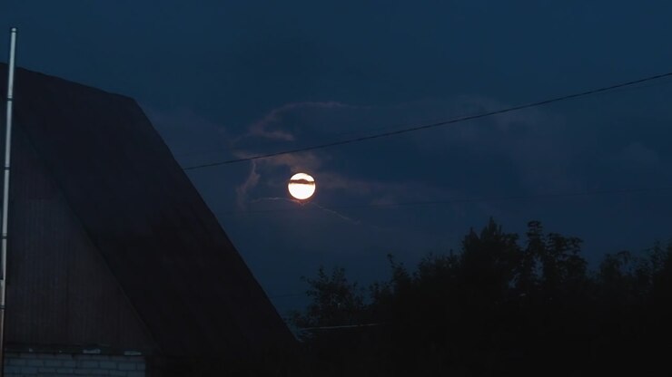 Luna piena luminosa parzialmente nascosta dalle nuvole di notte