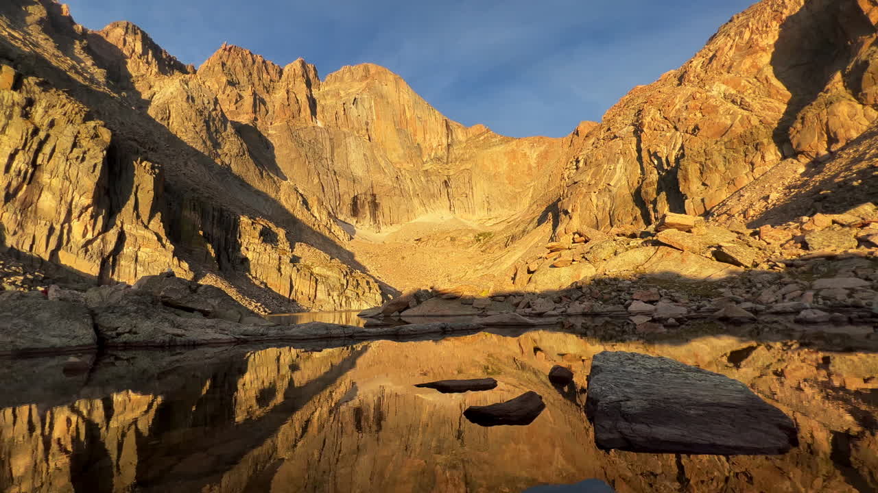 Chasm Lake sunrise on Longs Peak fourteener Rocky Mountain National Park RMNP first light summer hike mountaineer adventure trail reflection calm water stunning scenic landscape static shot