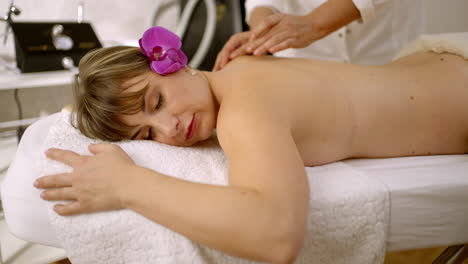 mujer recibiendo un masaje relajante en la espalda en un spa