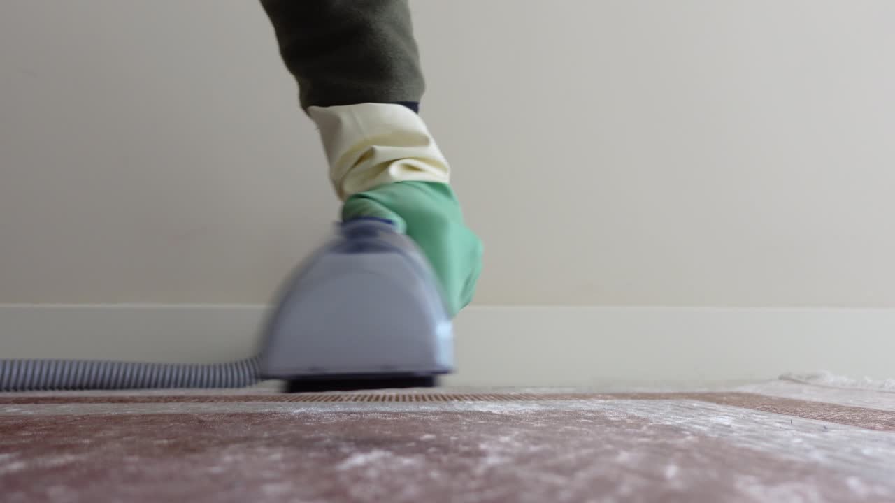 persona que está aspirando una alfombra