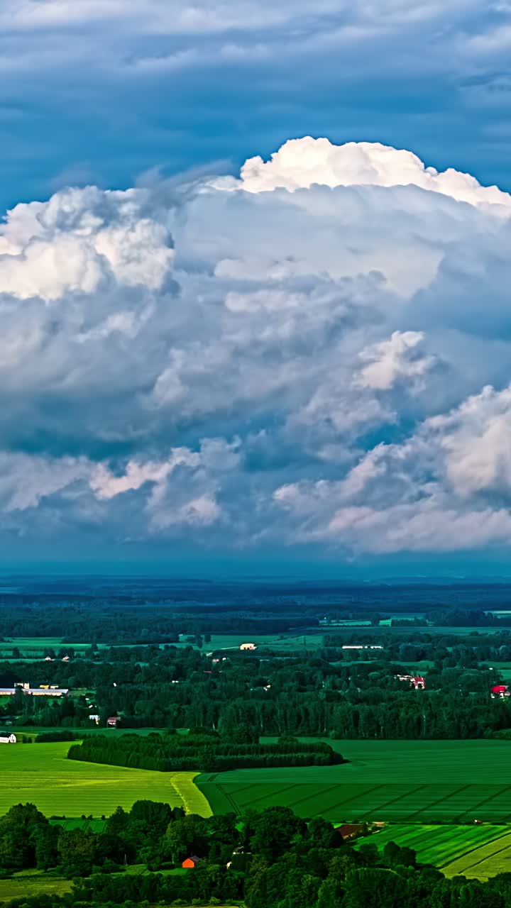 Timelapse of dramatic storm clouds over a vibrant green rural landscape, vertical