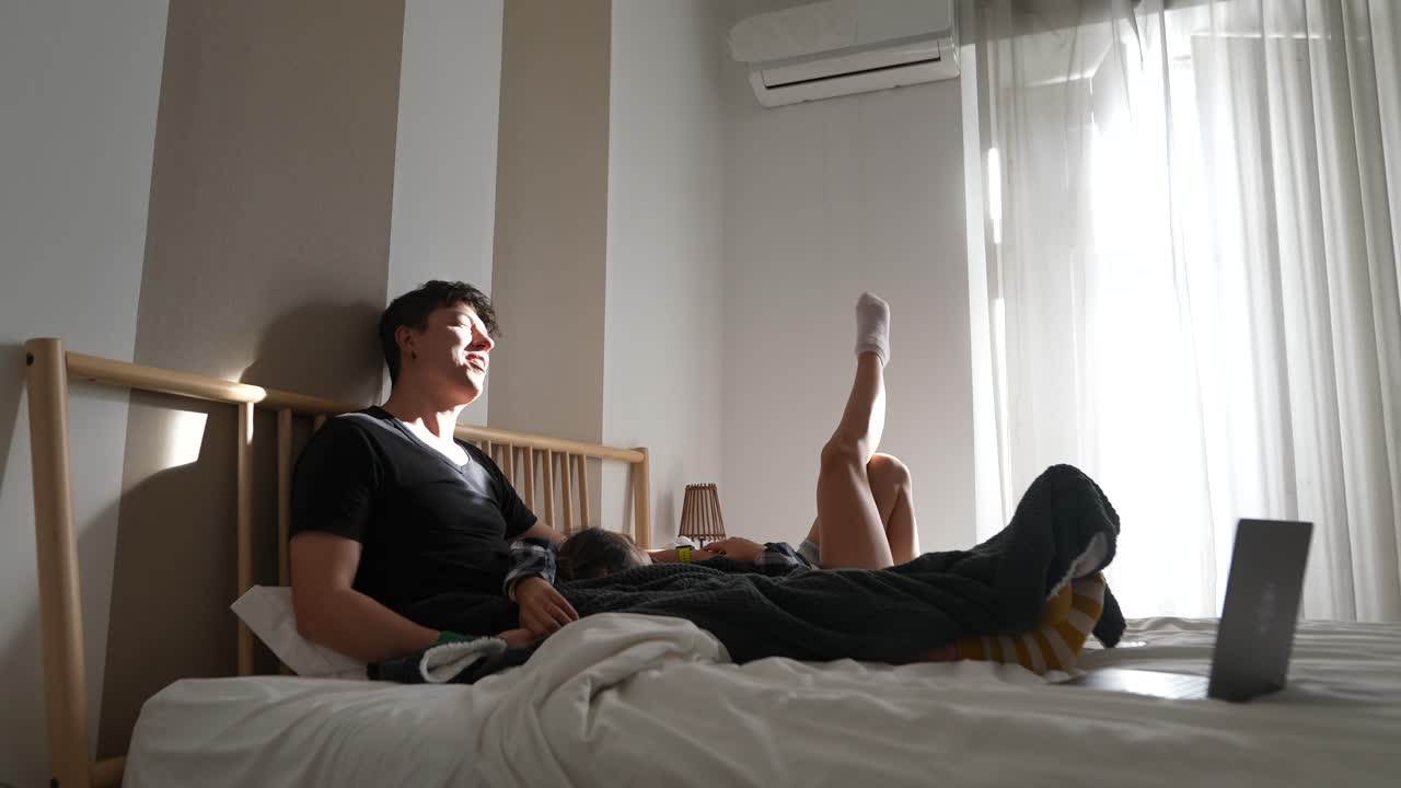 Couple and Child Relaxing in Bed