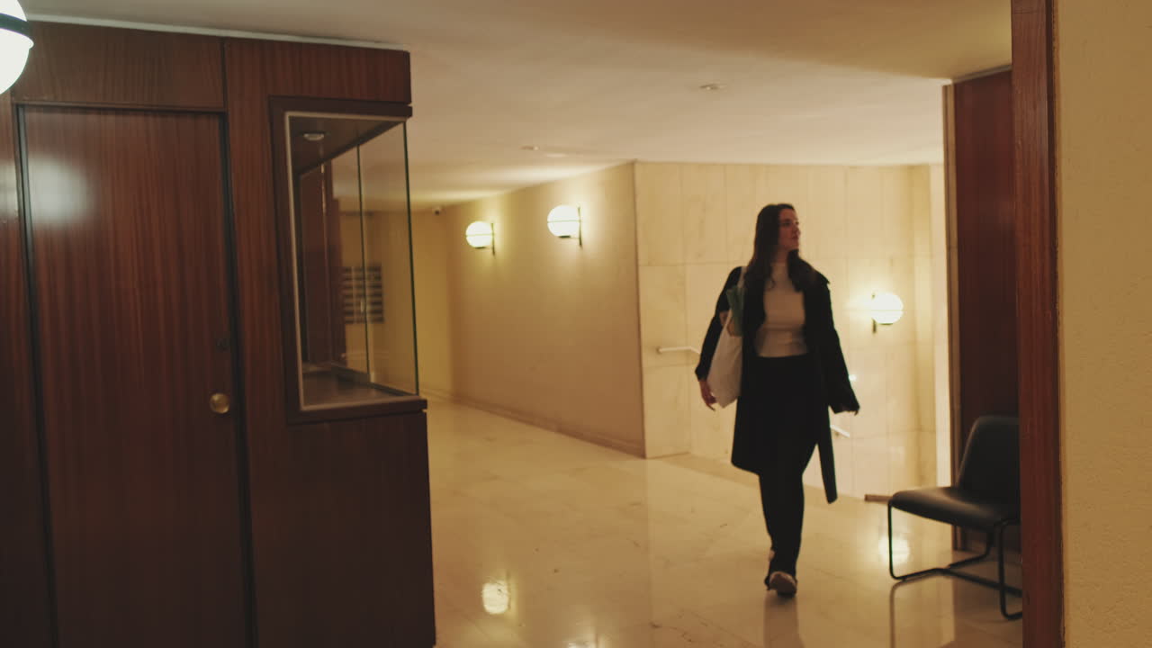 Woman walking in a hallway with a shopping bag