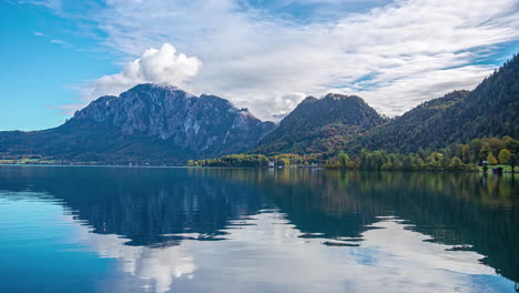 time-lapse of the beautiful destination austria directly on attersee lake with a view of the calm blue lake, the majestic mountains and passing clouds on a sunny morning