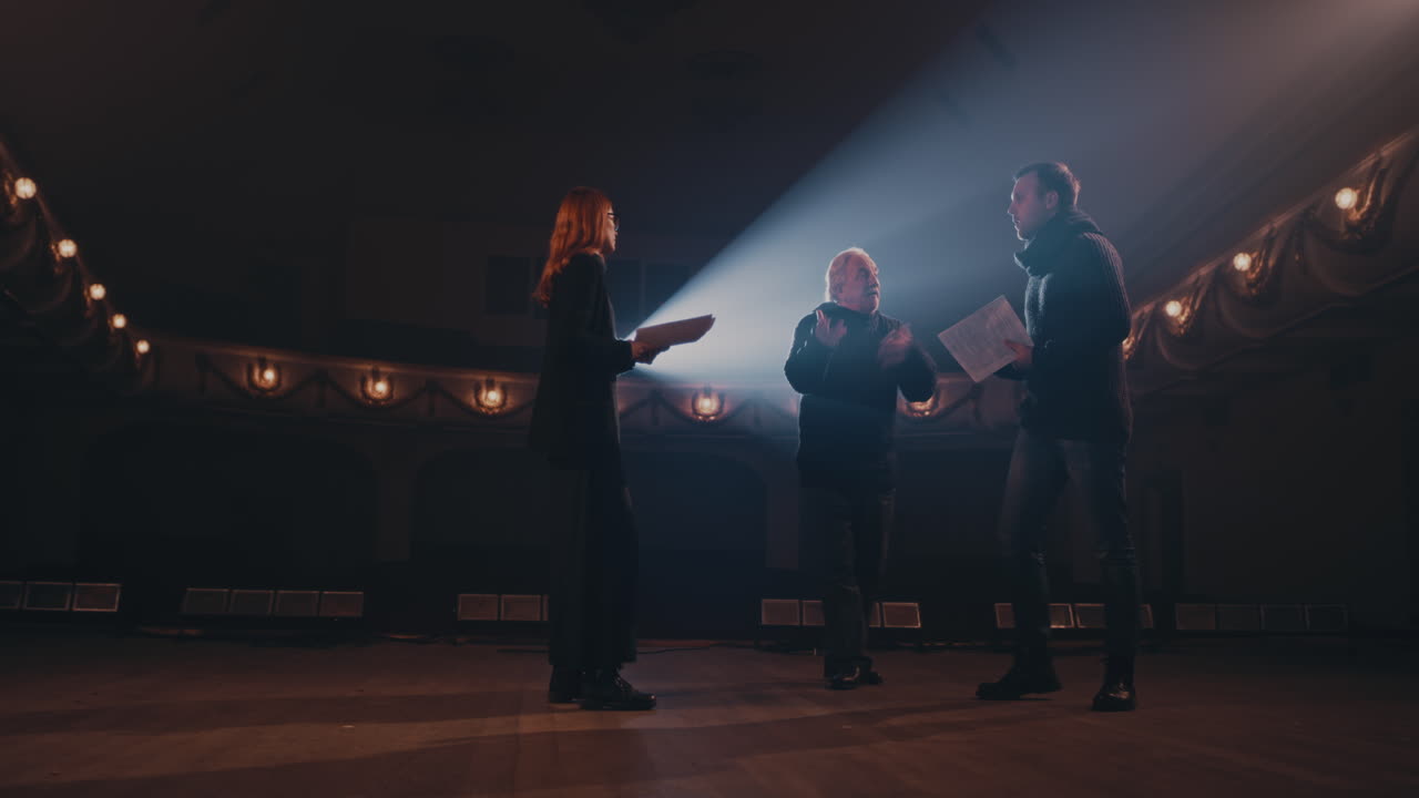 Elderly Director Supporting Actors during Quarrel Scene Senior Director Helping Man and Woman to Act out Argument Scene during Rehearsal on Stage in Theater