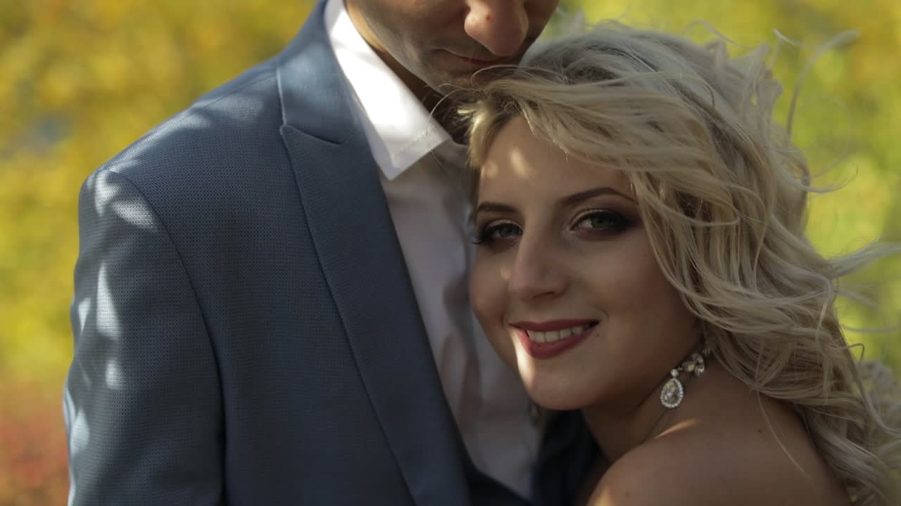 Coppia di sposi in piedi insieme nel parco. Novelli sposi. Sposo e sposa adorabili