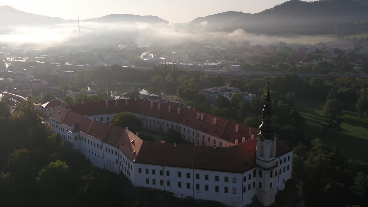 En drone avslører en panoramautsikt over byen Decin sett ovenfra, med utgangspunkt i et gammelt monument ved kanten av en skogkledd ås