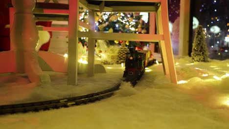 a toy christmas train riding around the track