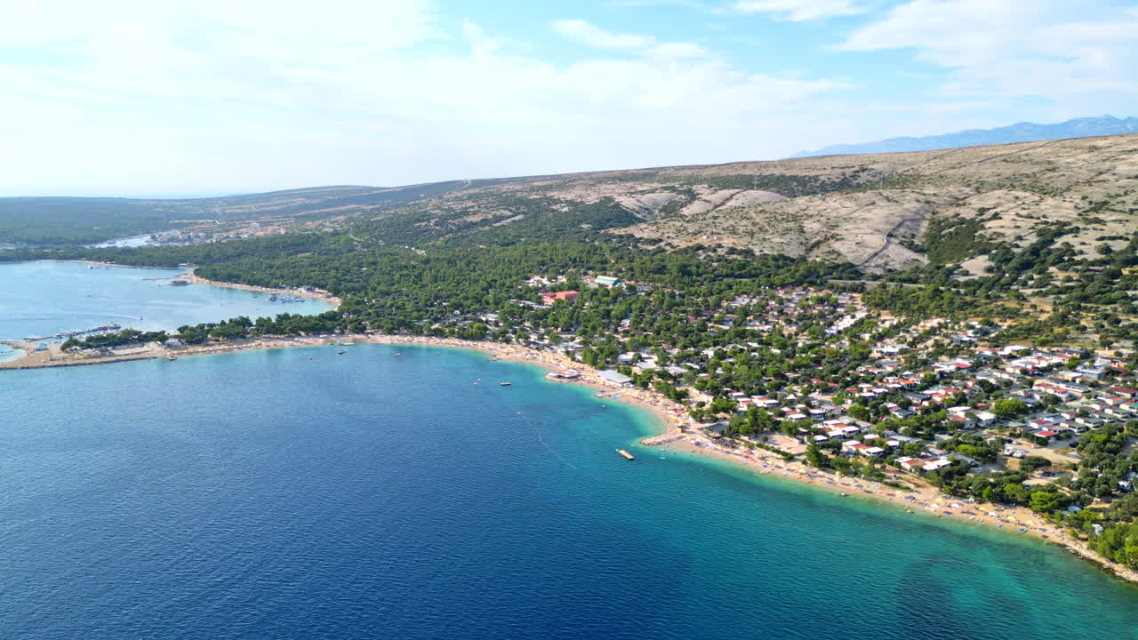 Aerial view of the croatian coastline of Simuni, Pag, showing turquoise water and sandy beach