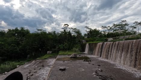 la vista en una cascada cuyo agua está nublada porque lleva barro y ceniza volcánica, es el camino de los flujos de lava fría