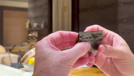 chef skillfully wraps sea urchin in seaweed