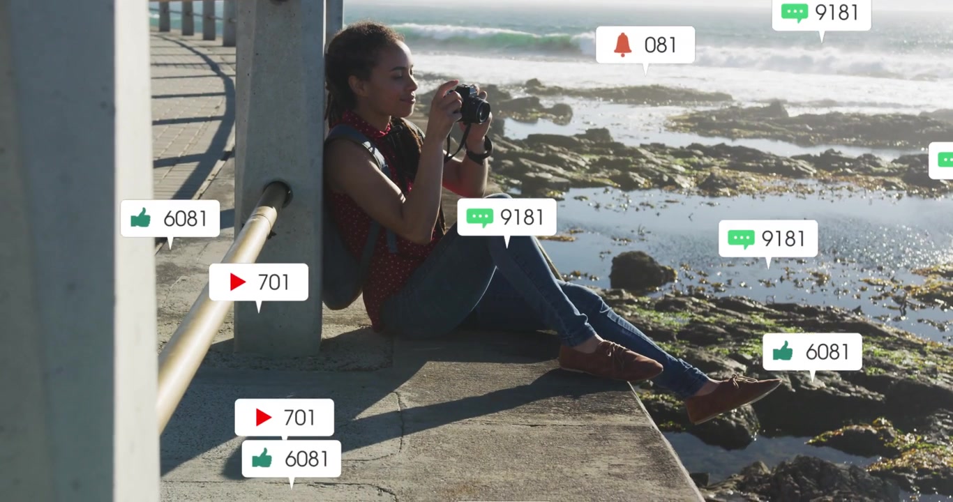 Female photog on pier raising DSLR, firing, spawning floating hearts, comments,views for marketing