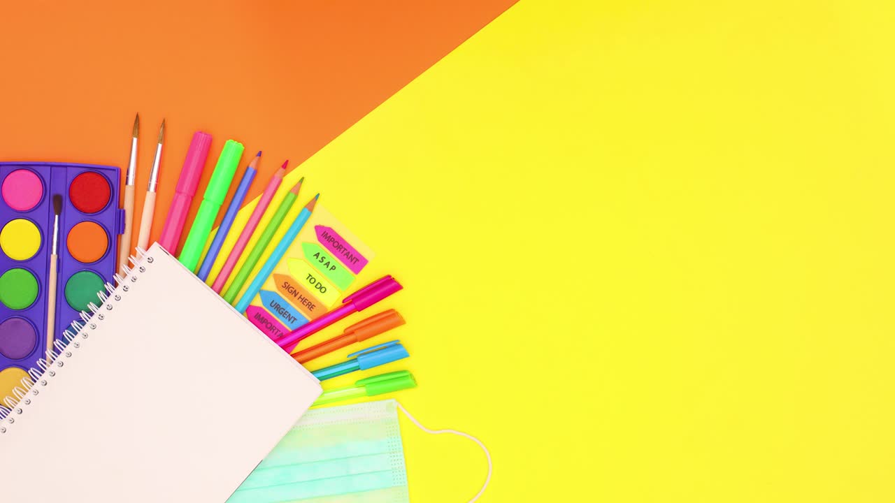 школьные канцелярские принадлежности перемещаются над открытым блокнотом.