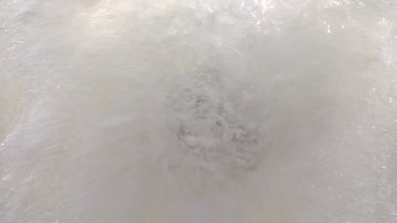 Electric outboard engine in clear acrylic tank. Propeller moving and water waves with air bubbles against the acrylic wall.