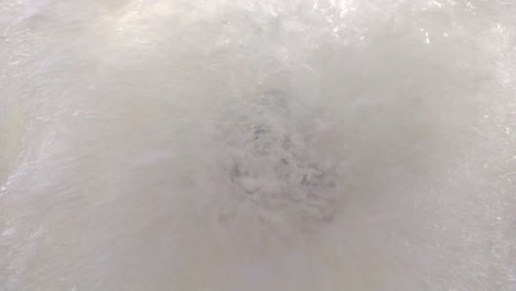 electric outboard engine in clear acrylic tank. propeller moving and water waves with air bubbles against the acrylic wall.