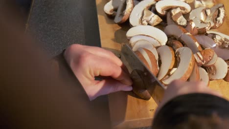 Close-up-of-fresh-mushrooms-being-sliced-by-a-woman-hand-preparing-a-healthy-recipe