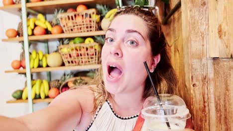 happy vlogger in a fruit bar with shelves of fruit